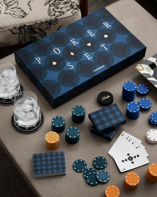 Art of Poker Set fully laid out with chips and cards on a table with water glasses and plates