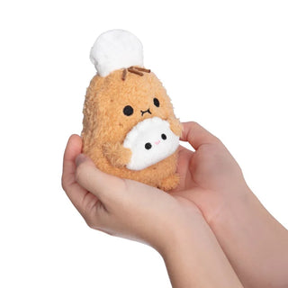 Small plush toy resembling a potato with a white dumpling and chef hat held in a hand against a white background