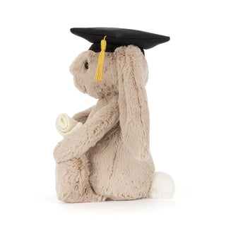 Side facing Plush toy bunny wearing a graduation cap on a white background