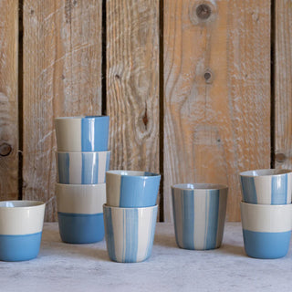 Set of blue and beige ceramic cups against a wooden background