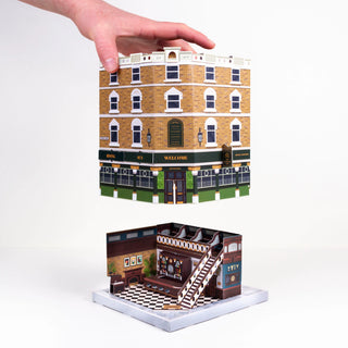 Constructing the build your own pub, hand holding the outer structure above the inner structure