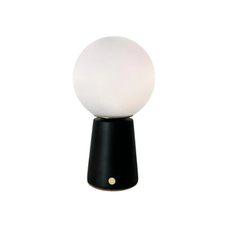 Table lamp with a black wooden base and white spherical shade on a white background