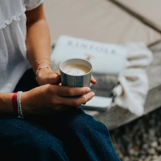 Person holding a cup of coffee with a blurred background