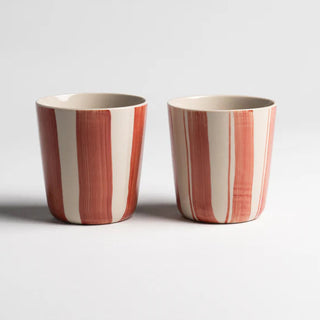 Two striped ceramic cups on a light gray background