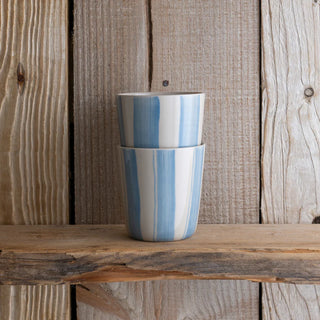 Two stacked ceramic cups with a blue and white pattern on a wooden surface