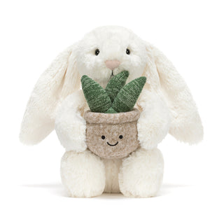 Plush toy bunny holding a potted plant on a white background