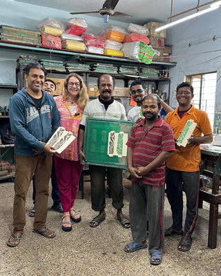 Group of people in a workshop holding packaging