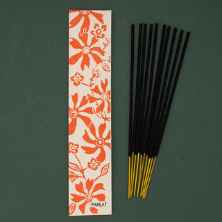 Incense sticks with a floral packaging label on a green background