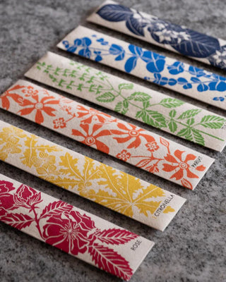 Set of colorful packaging with floral patterns on a gray surface