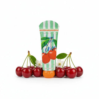 La Cerise Handcream tube green and white stripes with a cherry motif with cherries and white flowers beside and set against a white background