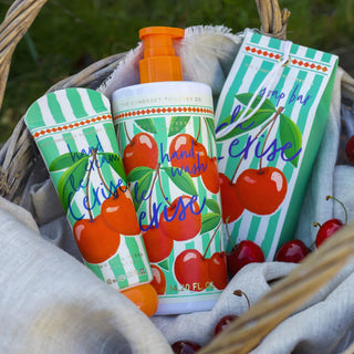 Cherry-themed hand wash, soap bar and handcream in a basket with cherries.