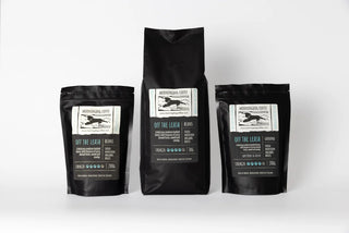 Three black coffee bags with labels on a white background