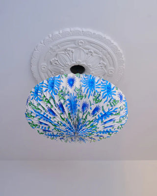 Looking up at a Decorative ceiling light shade with blue and green pattern on a white ceiling
