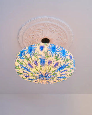 Decorative ceiling light fixture with blue & green lizard pattern on a white ceiling
