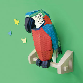 3d paper parrot on a wall mounted perch against a green background