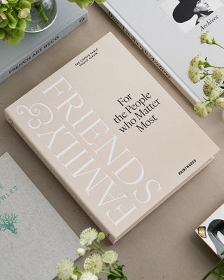 Book titled 'FAMILY & FRIENDS For the People Who Matter Most' on a surface with flowers and other books.