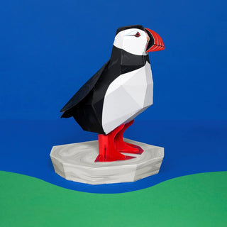 3D paper model of a puffin on a blue and green background