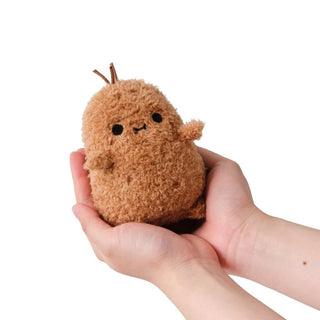 Small brown potato plush toy held in a hand against a white background