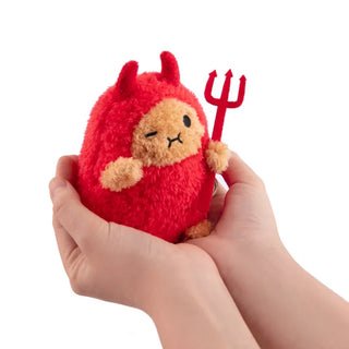 Small plush toy resembling a devil held in a hand against a white background
