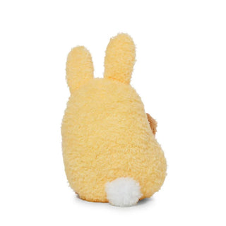 Back view of a plush potato toy dressed as a yellow bunny on a white background