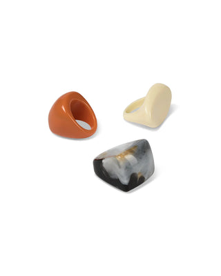 Three unique ring designs one bright orange, striking cream, and powerful marbled black on a white background.