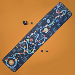 Full view of the Solar System Game board with cardboard die and spaceship game pieces against an orange background
