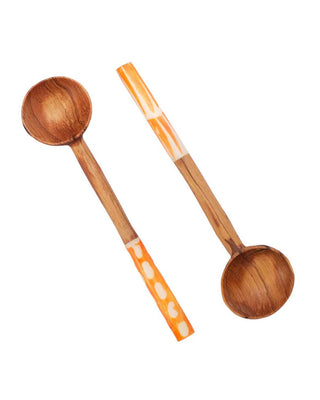 Two wooden spoons with orange handles on a white background