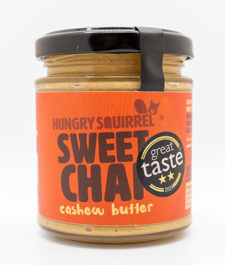 Jar of Hungry Squirrel Sweet Chai cashew butter with a 'Great Taste' award label on an orange background