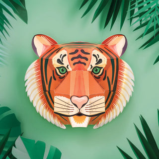 Straight on view of a 3d paper tiger head with green foliage background