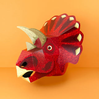 red 3d paper triceratops mask against an orange background