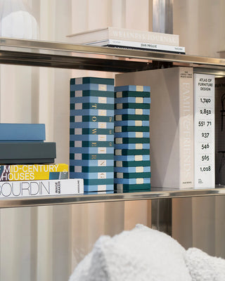 Tumbling Tower game and packaging on a shelf surrounded by decorative books