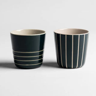 Two striped ceramic cups on a light gray background