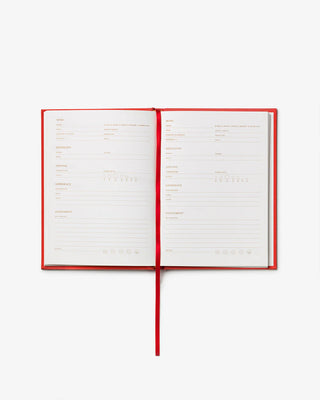 Open notebook with red binding on a white background showing journalling space for notes on wine tasting