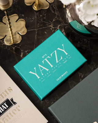Teal Blue Yatzy box against a dark marble surface